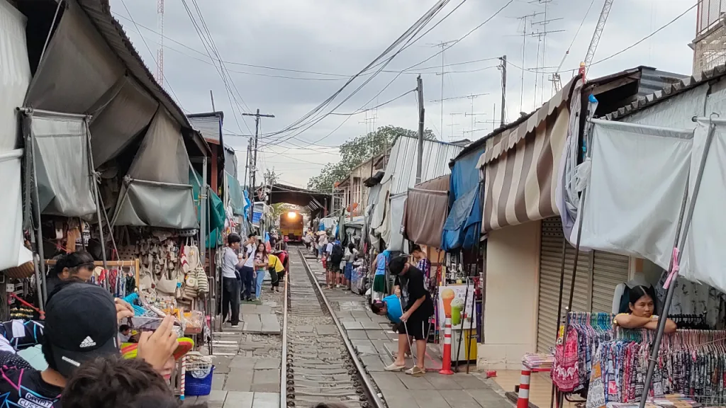 メークロン市場から見るメークロン駅を出発する列車
