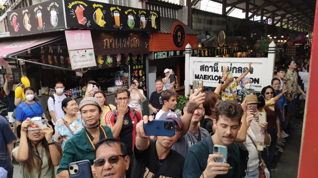 メークロン駅に到着する列車を待ち構える観光客