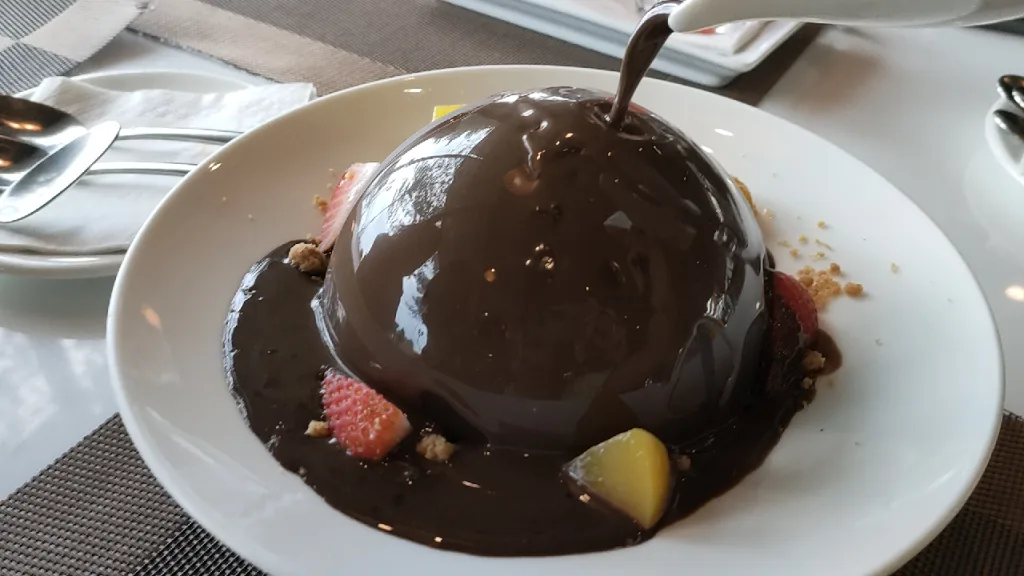 チョコレートファクトリー・パタヤ・プラタムナックヒル店のチョコレートドームに温かいチョコレートをかけているところ