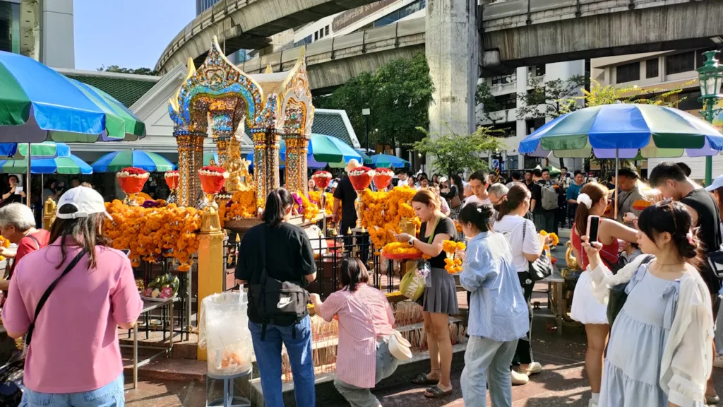 横から見たエラワンの神様とお祈りする人々