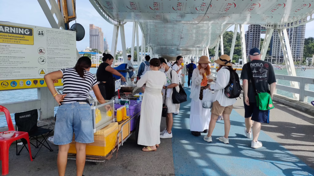 バリハイ桟橋内のフェリー乗り場付近で営業する屋台で買い物する下船客