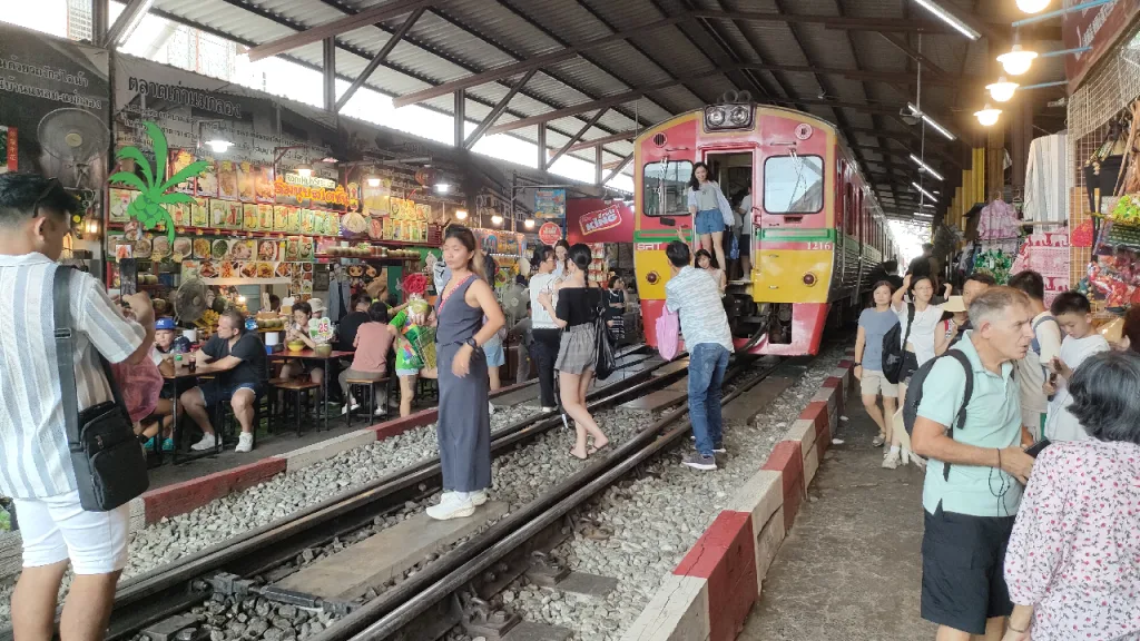 タイ国鉄のメークロン駅に停車中の列車で記念撮影をする人々