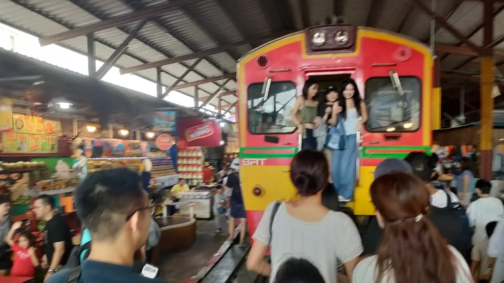 タイ国鉄のメークロン駅に停車中の列車で記念撮影のために順番待ちする人々