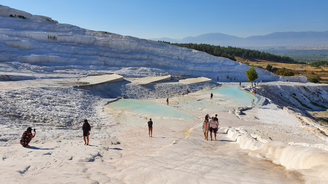 トルコ パムッカレで石灰棚に入る観光客