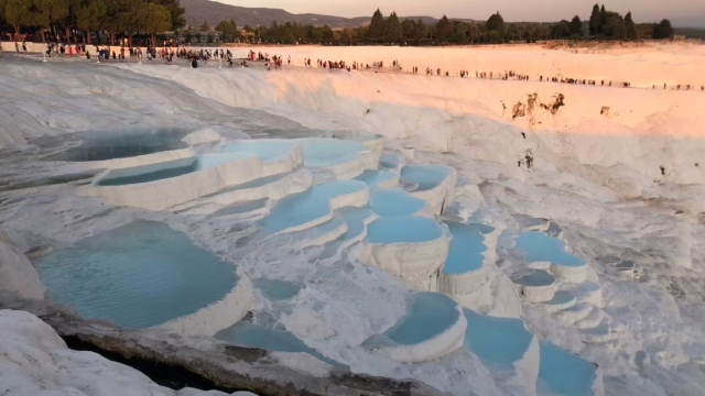 トルコ パムッカレで多くの観光客が見学する石灰棚